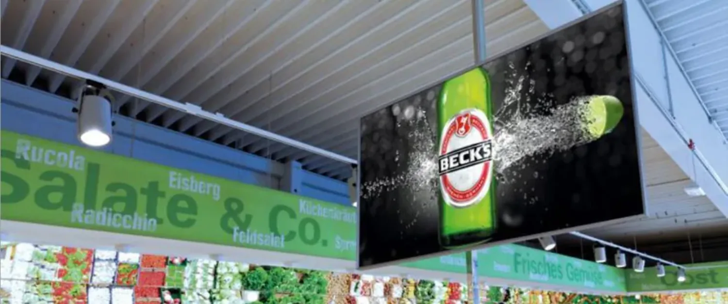 Edeka-TV-Screen mit Beck's-Werbung über dem Frischebereich Salate & Co.